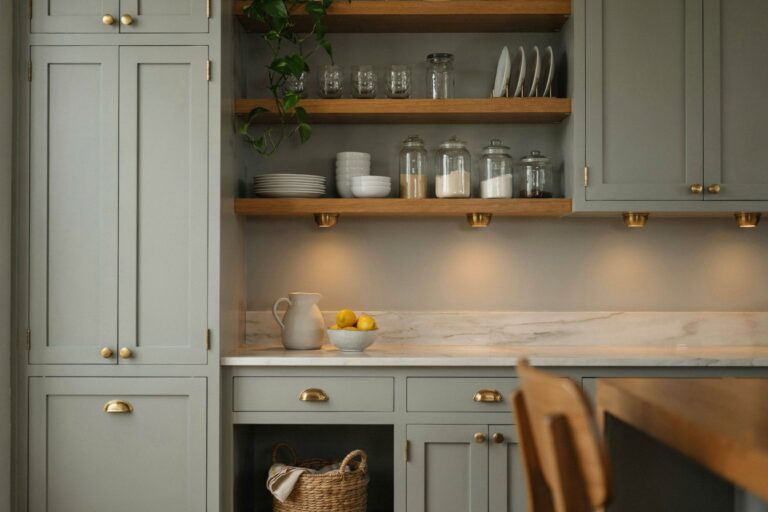 Butlers pantry with cabinets painted muted gray-green and brass hardware